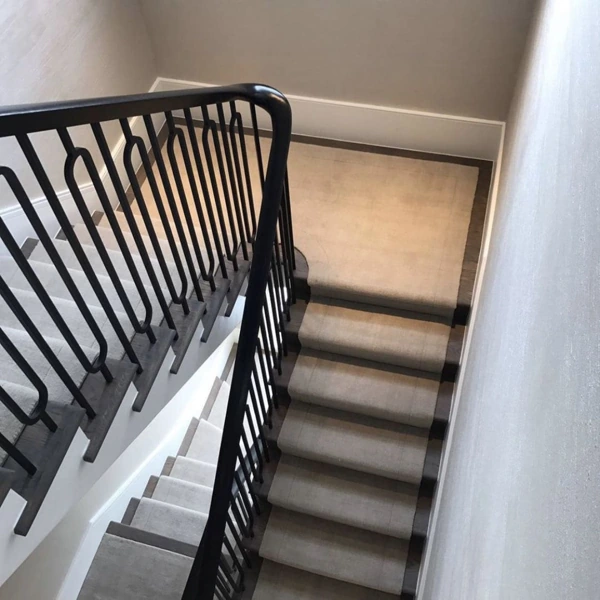 Light grey runner carpet on dark wooden stair steps
