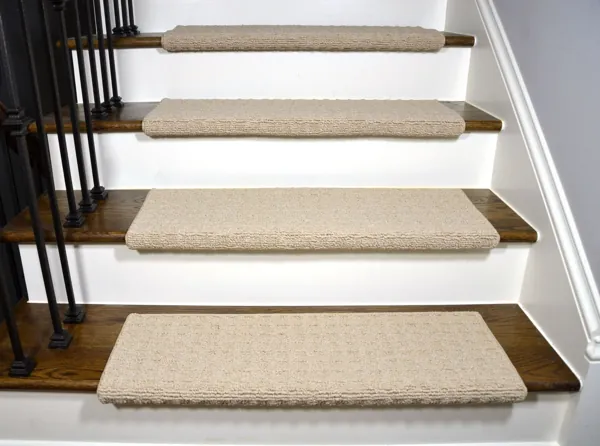 Beige carpet stair treads on dark wood steps with white risers