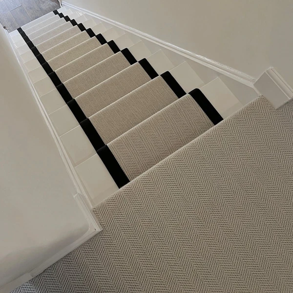 Beige herringbone stair runner with black tape border