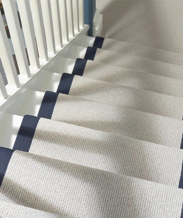 Beige stair carpet with a dark blue border.