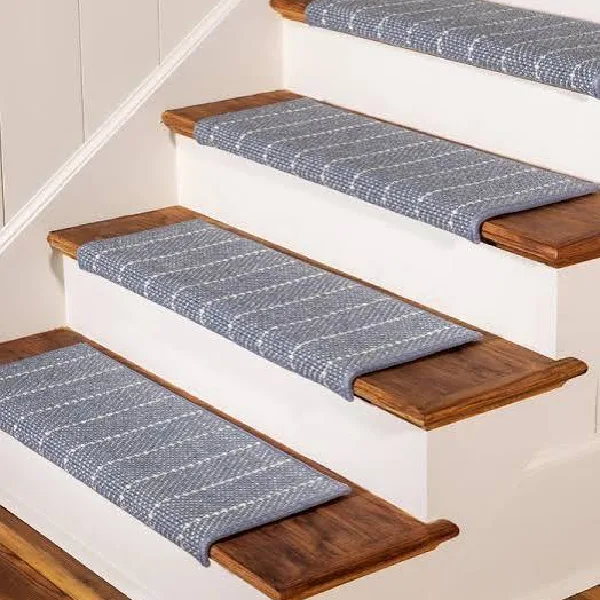 Blue patterned carpet stair treads on wooden steps with white risers.
