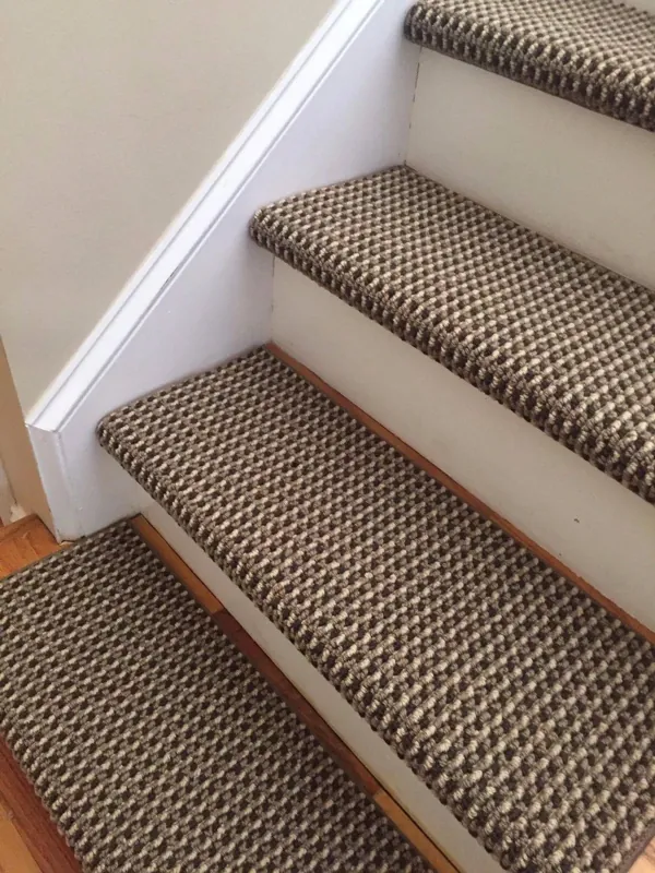 Brown and beige checkerboard-patterned carpet stair treads on wooden steps