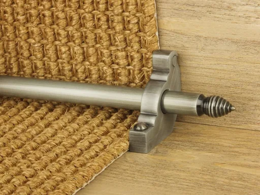 Brushed nickel stair rod with a beehive finial securing a woven natural fiber carpet runner.