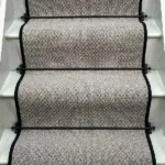 Charcoal Small Boucle Grey Wool Stair Runner with a black binding and black stair rods.