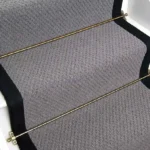 Charcoal Small Boucle Grey Wool Stair Runner with a black border and brass stair rods.