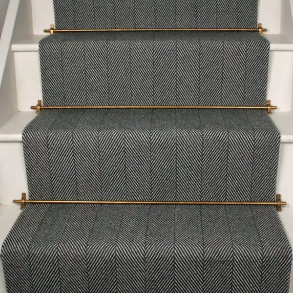 Charcoal herringbone stair carpet with brass rods.