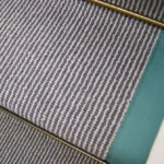 Close-up of Country House Grey Shingle Striped stair runner with teal edging and brass stair rod.