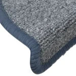 Close-up view of textured blue-grey carpet stair tread with wrapped bullnose edge.
