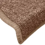 Close-up view of textured brown carpet stair tread with wrapped bullnose edge.