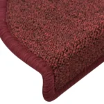Close-up view of textured burgundy red carpet stair tread with wrapped bullnose edge.