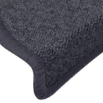 Close-up view of textured dark navy carpet stair tread with wrapped bullnose edge.