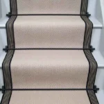 Fibre Flooring Highclere Wool Herringbone Stair Runner on a staircase with a striped border.