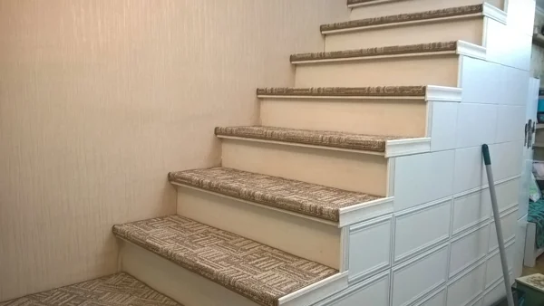 Geometric patterned brown and beige carpet stair treads on white stairs