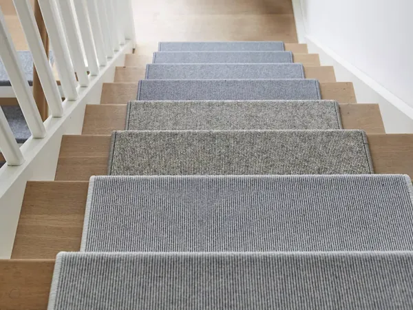 Gray and blue carpet stair treads on wooden steps