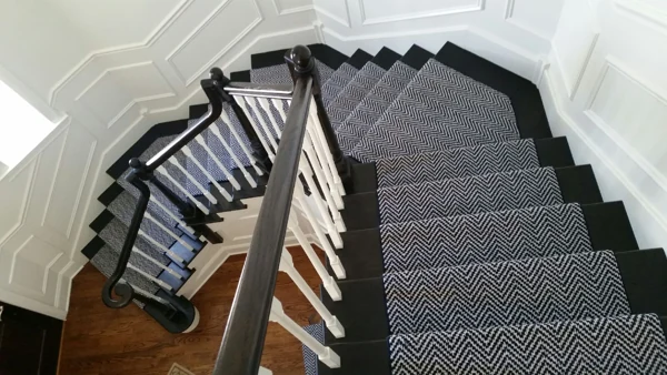 Navy and white herringbone stair runner on black stairs.