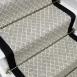 Park Lane wool flatweave stair runner with black edging and brass stair rods.