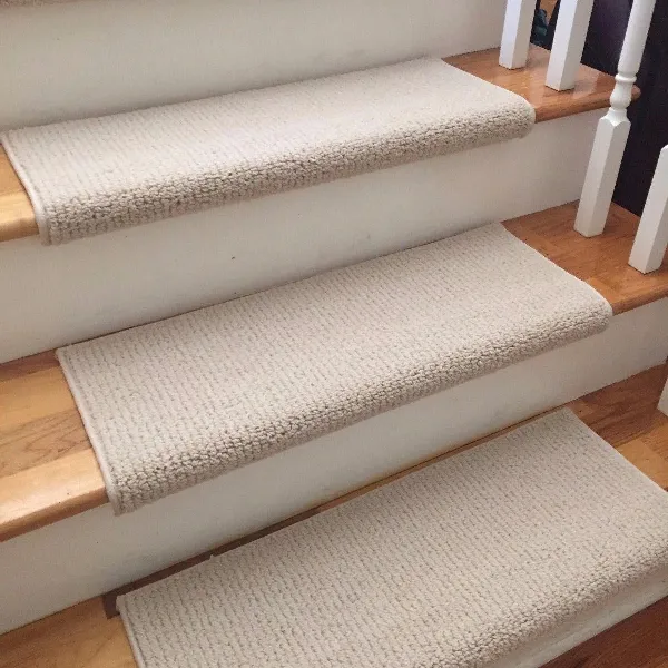 Ribbed beige stair carpet treads on wooden steps