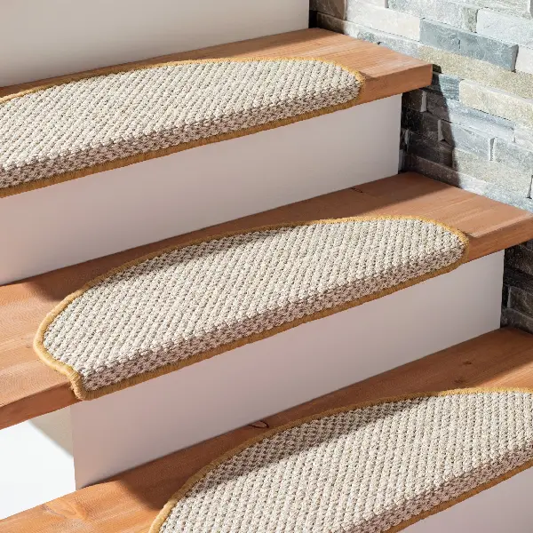 Semicircular beige carpet stair treads with brown bound edges