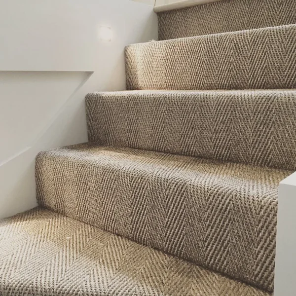 Close-up of beige sisal herringbone pattern stair carpet