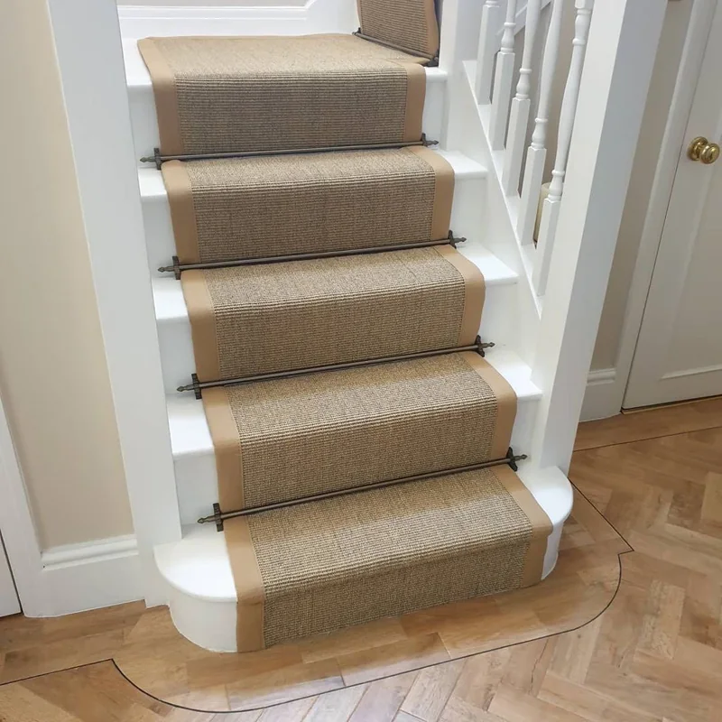 Sisal stair runner with brass carpet rods on white stairs