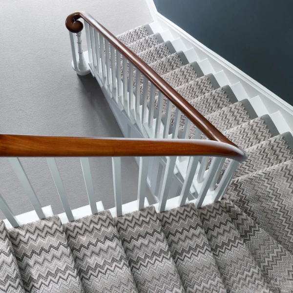 Staircase-with-zigzag-patterned-carpet-runner-in-gray-and-beige