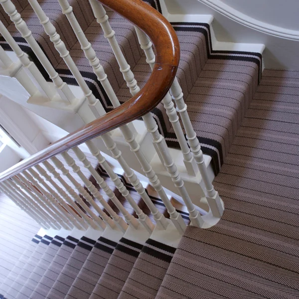 Taupe chevron wool stair runner with dark striped borders.