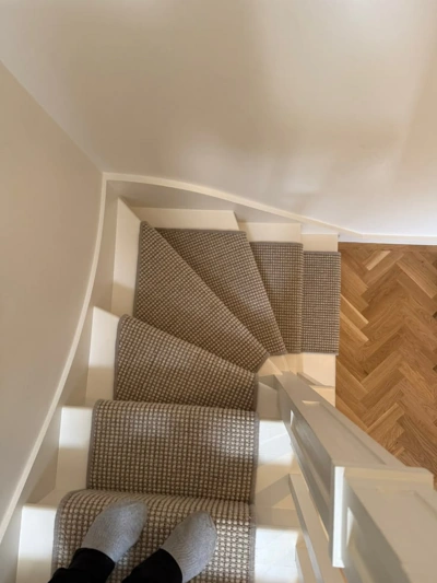 Top-down view of grey patterned runner on curved stairs