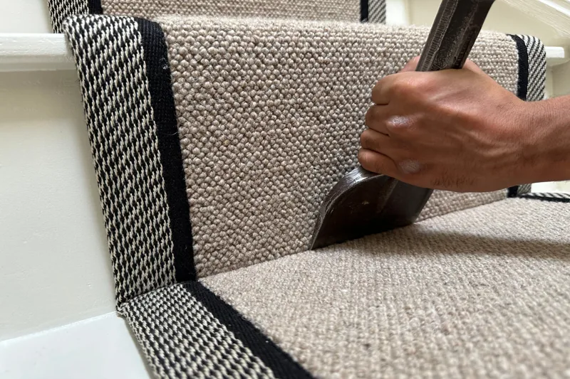Tucking woven carpet runner edge into stair crevice