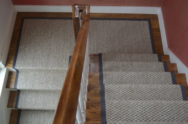Woven neutral-toned stair runner with dark fabric borders