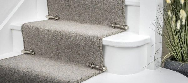 gray wool stair carpet secured on white stairs with polished chrome stair clips.