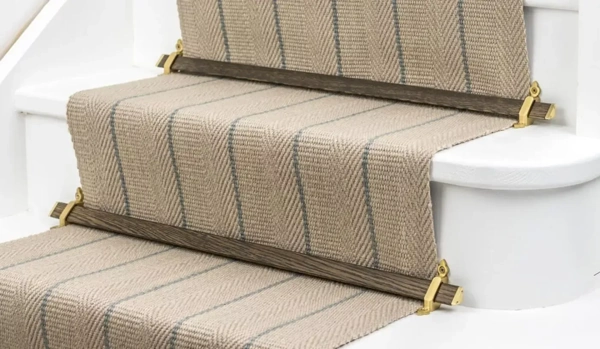 white stairs with wooden stair rods and brass brackets.